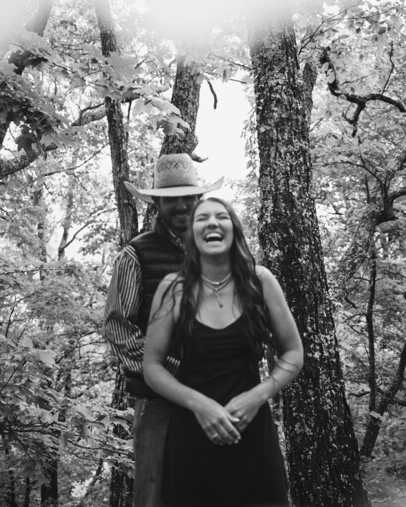 An example of what to wear for an engagement session in the woods: a button-down shirt and cool black dress with sturdy footwear.
